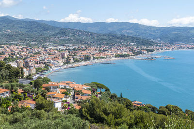 High angle view of townscape by sea against sky