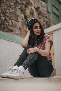 Portrait of smiling young woman sitting outdoors