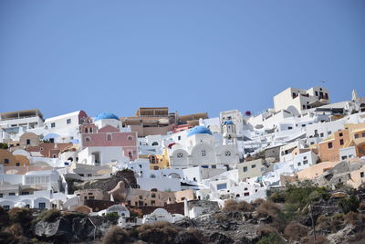 Low angle view of townscape against clear blue sky