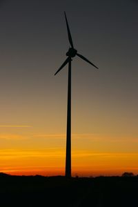 Low angle view of silhouette wind turbine against sky during sunset