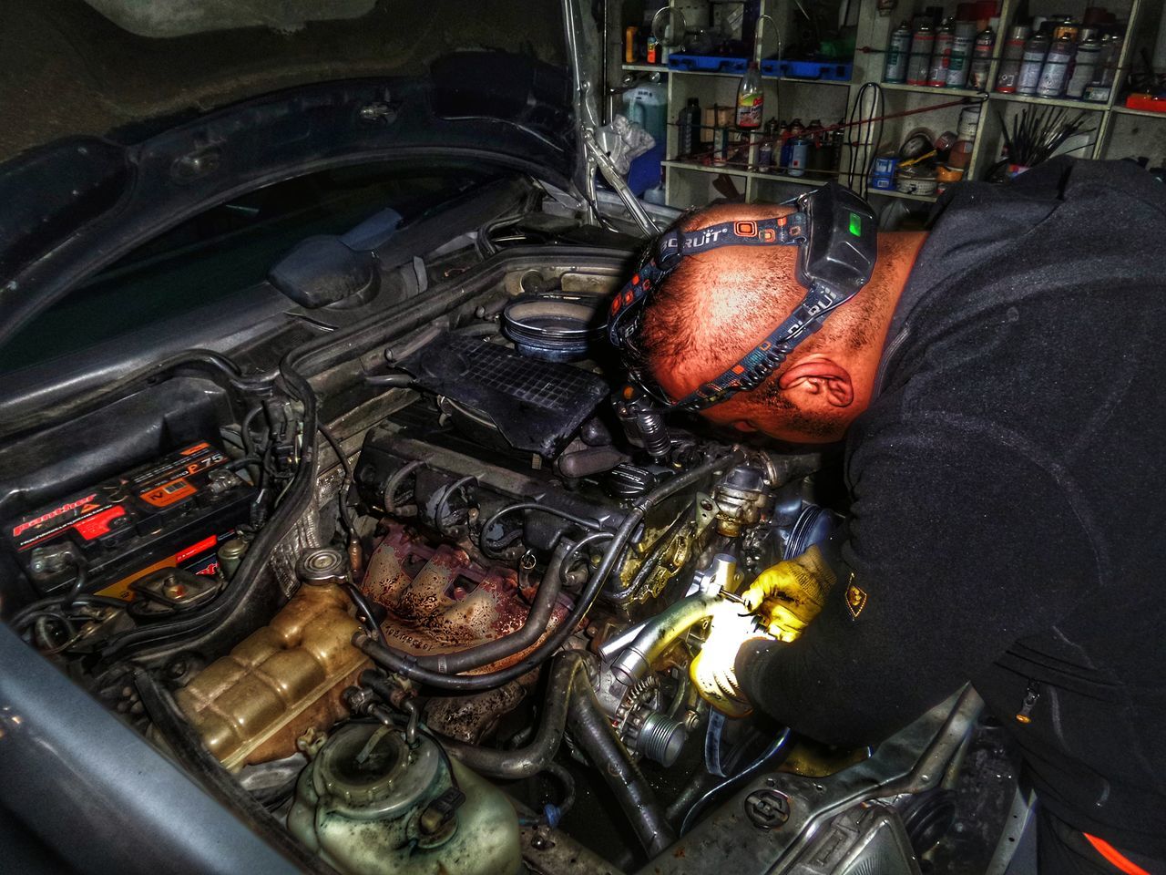 CLOSE-UP OF MAN WORKING ON CAR