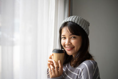 Portrait of young woman drinking coffee