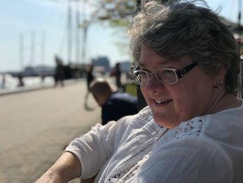 Smiling mature woman wearing eyeglasses looking away in city