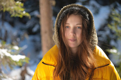 Winter walk through the forest, snow-covered beautiful pine forest. portrait of a young lovely woman