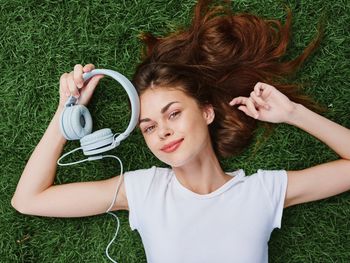 High angle view of young woman holding headphones