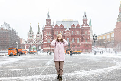 Full length of young woman standing in city