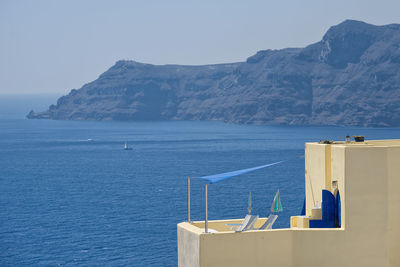 Scenic view of sea and mountains against clear sky