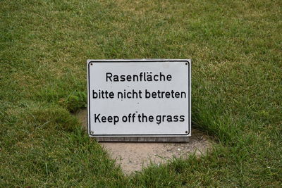 Close-up of information sign on grass