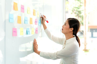 Side view of young businesswoman preparing strategy in office