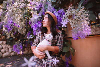 Portrait of young woman sitting on christmas tree