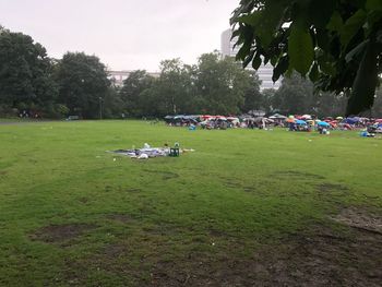 People on field in park against sky