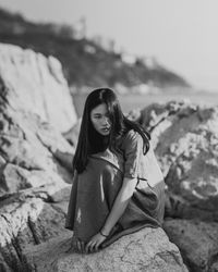 Portrait of woman sitting on rock