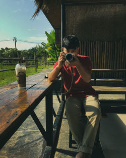 Full length of man photographing at camera