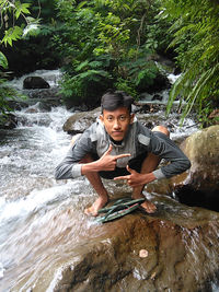 Portrait of young man sitting in water