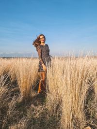 Full length of woman standing on field against sky