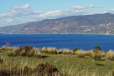 Scenic view of sea and mountains against sky