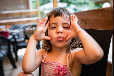 Portrait of happy little girl making funny face