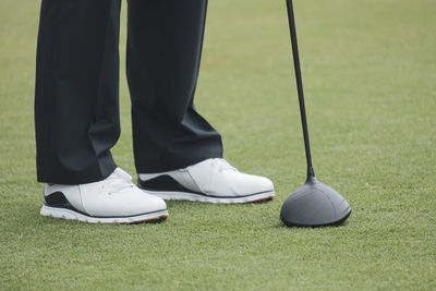 Low section of man standing on golf course