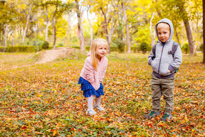 Full length of smiling girl standing in autumn