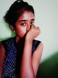 Portrait of cute girl against wall at home