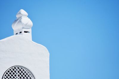 High section of white building against clear blue sky