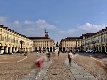 Group of people walking in front of buildings