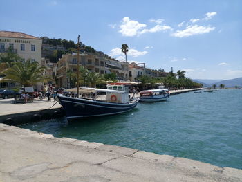 Boats moored at harbor by town