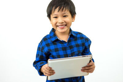 Happy boy standing against white background