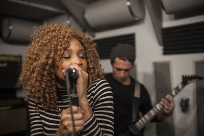 Close-up of woman singing on microphone