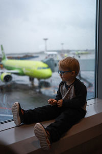 Boy sitting on airplane window