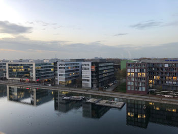 Reflection of buildings in river against sky