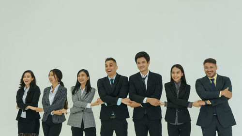 Portrait of friends standing against white background