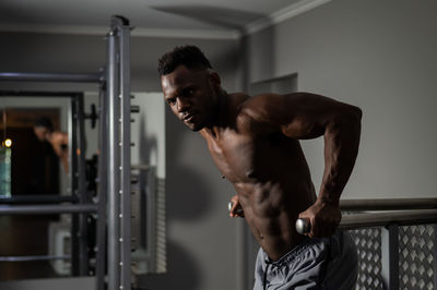 Shirtless man exercising in gym