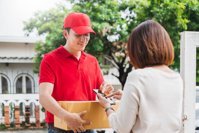 Young man with woman standing against red background