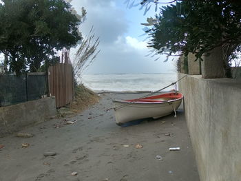 Boats moored on beach against sky