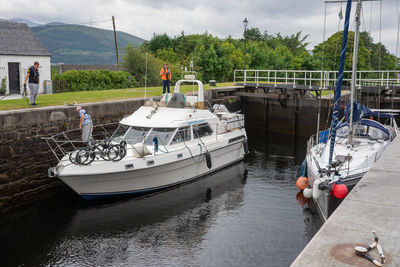 Boats moored in river against sky