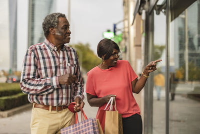 Senior woman doing window shopping with man