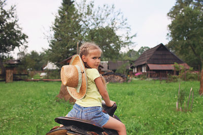 Full length of girl sitting on field