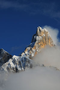 Scenic view of clouds over mountain against blue sky