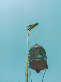 Low angle view of communications tower against clear blue sky