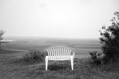 Chair on field against sky