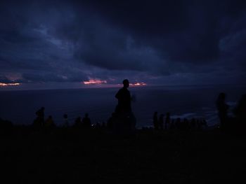 Silhouette of man standing by sea against sky at sunset