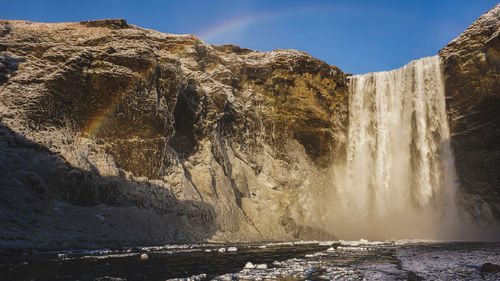 Scenic view of waterfall against sky