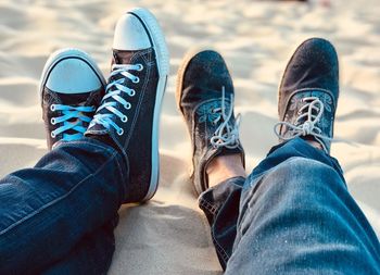 Low section of man and woman relaxing on sand