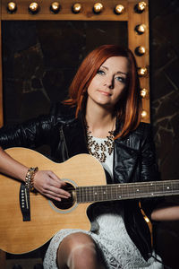 Portrait of a young woman playing guitar