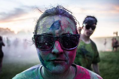 Close-up portrait of woman in sunglasses covered with powder paint