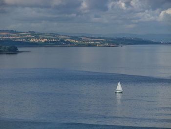 Sailboat sailing on sea against sky