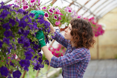 Side view of florist arranging flowers in shop