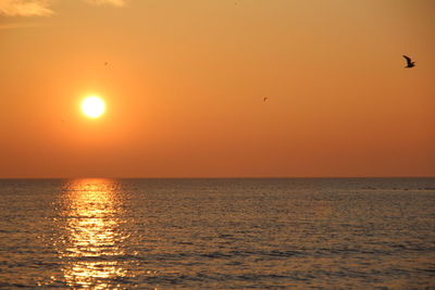 Scenic view of sea against orange sky