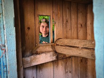 Portrait of boy peeking through window